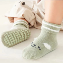 Load image into Gallery viewer, Tot and Toe Everyday Fold premium anti-slip grip socks, yoga socks for babies and toddlers learning to walk, full grip under sole, cotton socks with foldable cuff, cute print and fluffy details, toddler wearing green pair showing features of the sock.